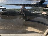 a reflection of a man standing in the reflection of a car door