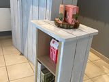 une petite table avec une étagère au milieu