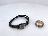 pair of silver and black leather bracelets on a white surface