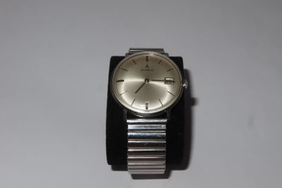 a silver watch with a black band on a white surface