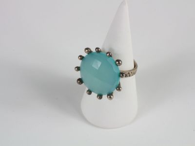a close up of a ring with a blue stone on it