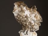 a statue of an owl sitting on top of a wooden post