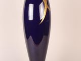 a blue vase with a gold leaf on it