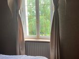 un lit dans une chambre avec une fenêtre et un tapis au sol