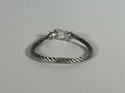 a close up of a silver bracelet on a white surface