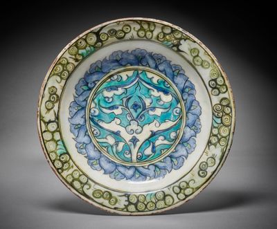 une image représentant une assiette bleue et verte ornée d'un motif
