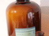 a brown glass bottle next to a brown glass bottle with a cork stopper