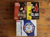 three books and a watch sitting on a wooden floor