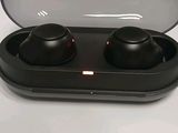 a pair of black earphones in a case on a table