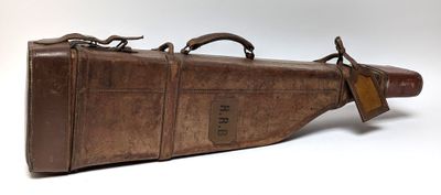 un étui en cuir marron orné d'une étiquette marron, posé sur une surface blanche