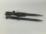 two knives are laying on a white surface with a knife in the middle