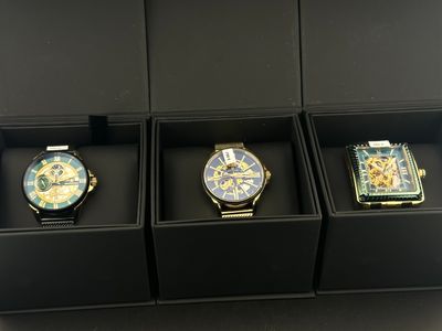 trois montres présentées dans un coffret noir dans une vitrine de magasin