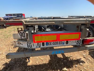 une photo d'une remorque à plateau garée sur le bord de la route