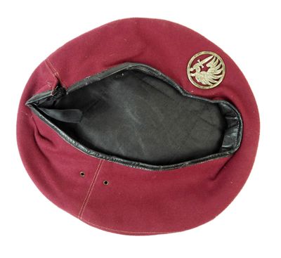 un chapeau rouge orné d'un emblème doré
