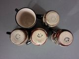 four coffee cups sitting on top of a table next to each other