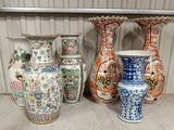 several vases are lined up on a shelf in a room
