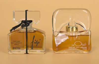 two small bottles of perfume sitting next to each other on a table