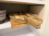 a wooden cutting board on a shelf next to a basket