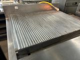 a large metal grill with a yellow hose on it