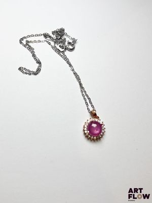gros plan d'un collier sur une surface blanche avec une chaîne