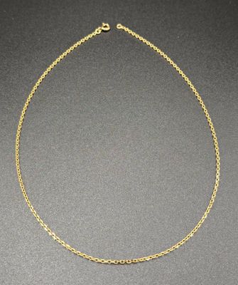 a gold chain necklace with three small beads on a black surface