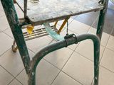 a metal table with a metal tray on it on a tiled floor