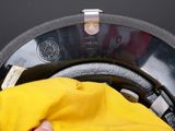 someone is cleaning a washing machine with a yellow cloth