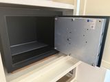 an open safe box in the middle of a cupboard