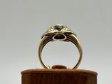 a close up of a gold ring on a wooden stand
