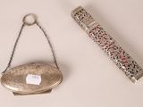 a silver purse and a silver lighter on a table