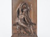 une sculpture en bronze représentant une femme assise sur un banc