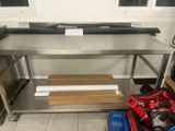 une grande table de travail en acier inoxydable équipée d'une étagère