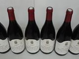 six bottles of red wine are lined up in a row