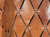 a close up of a brown leather bag with rivets on it