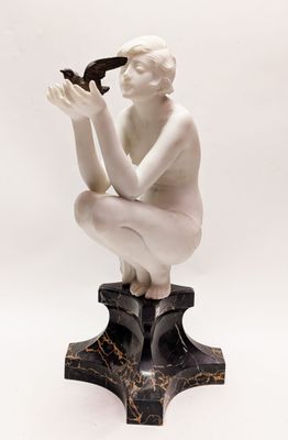 a statue of a woman kneeling on top of a black and white base