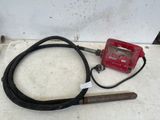 a red radio and a black cord on the floor