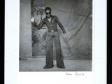 an old photo of a man in a suit and sunglasses holding a camera