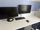 two computer monitors on a desk with a keyboard and mouse