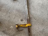 une photo montrant une paire d'outils posés sur un sol en béton