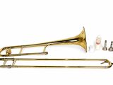 the trombone is laying on a white surface next to other musical instruments