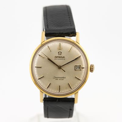 une image représentant une montre dorée et noire sur fond blanc