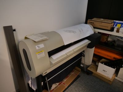 une grande imprimante posée sur un bureau dans une pièce