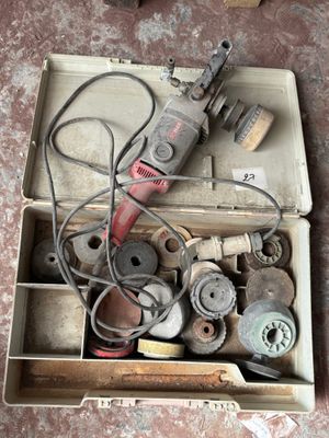une boîte remplie d'outils divers posée par terre