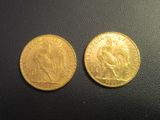 a close up of two gold coins on a black surface
