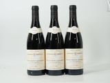 trois bouteilles de vin posées sur une table blanche