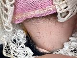 a close up of a doll wearing a pink hat