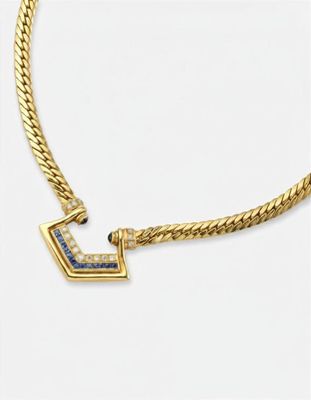 un collier en or jaune orné d'un pendentif en diamants bleus et blancs