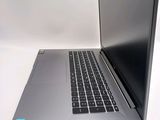 a laptop computer sitting on a white surface with a blue sticker on it