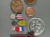 a lot of coins and medals that are on the table