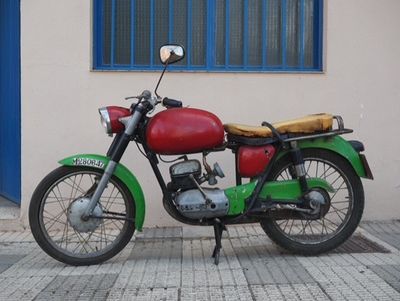 a red and green motorcycle parked in front of a building